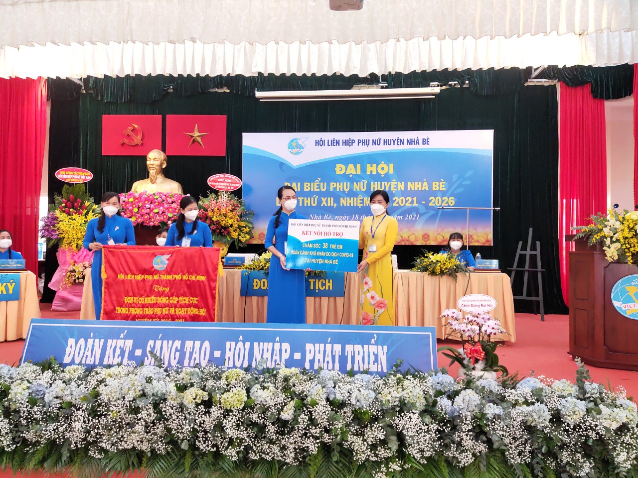 Bà Nguyễn Trần Phượng Trân - chủ tịch Hội LHPN TP trao cờ biểu dương và bảng tượng trưng nhận đỡ đầu 38 trẻ có hoàn cảnh khó khăn trên địa bàn huyện Nhà Bè