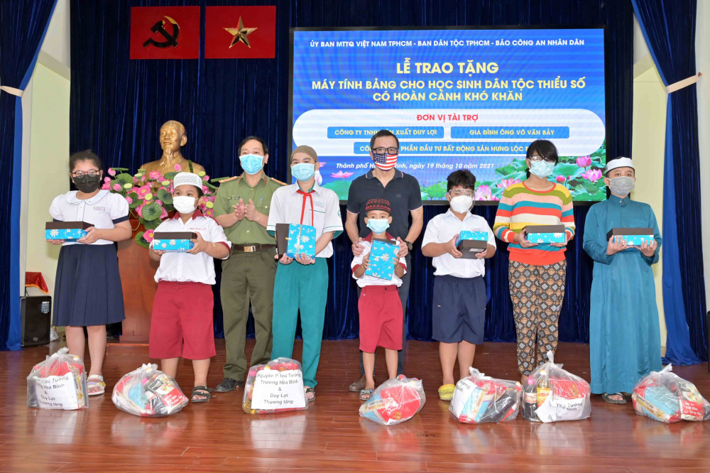 Các nhà tài trợ trao máy tính bảng cho các em học sinh dân tộc Chăm và Khmer. Ảnh: Quốc Thanh.