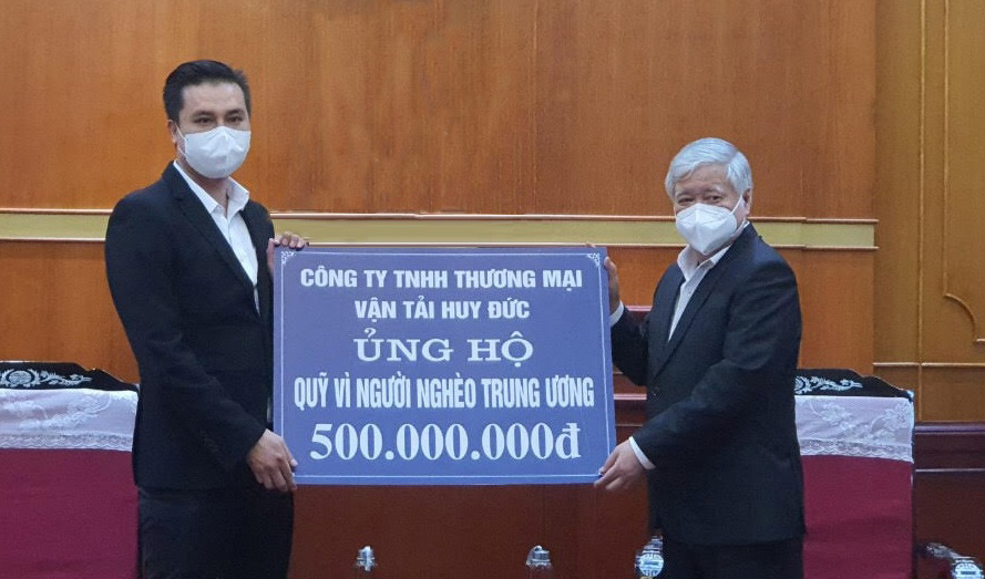 Ông Võ Ngọc Tài đại diện Công ty TNHH Thương mại Vận tải Huy Đức trao tiền ủng hộ Quỹ “Vì người nghèo” - Ảnh: Lan Anh