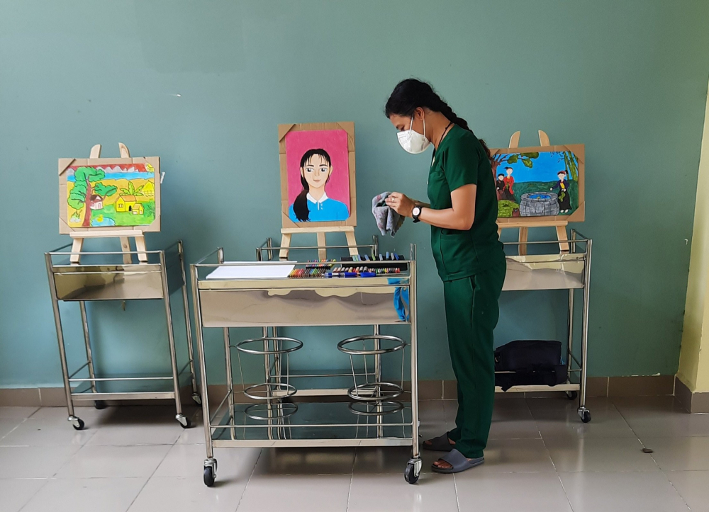Cô giáo Bùi Ngô Y Hân chuẩn bị một tiết dạy học trực tuyến ở một góc bệnh viện dã chiến Q.8 sau những giờ chăm lo cho bệnh nhân F0