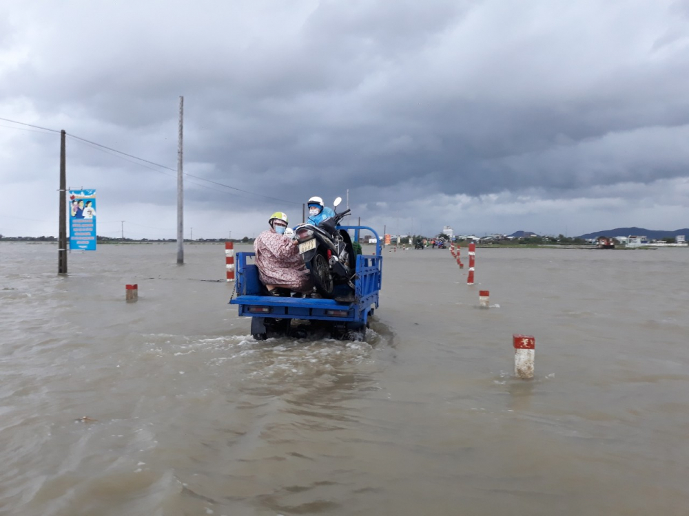Người dân ở xã Phước Thắng, huyên Tuy Phước di chuyển bằng xe lớn qua các vùng ngập sâu
