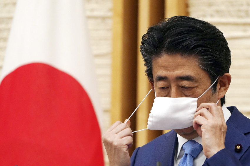 Thủ tướng Nhật Bản khi đó là Shinzo Abe tháo khẩu trang trước khi phát biểu trong cuộc họp báo tại dinh thự chính thức của ông ở Tokyo.