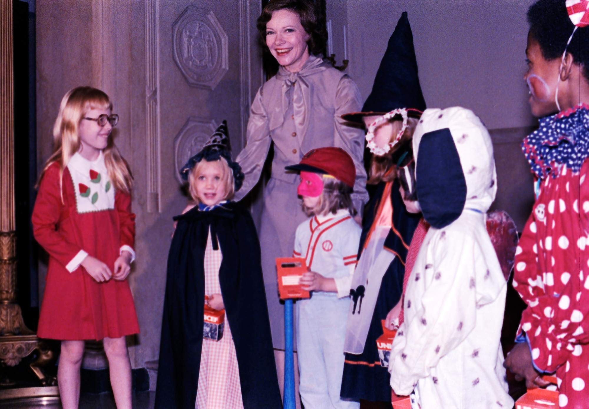 Rosalynn Carter và con gái Amy tổ chức những trò lừa trẻ cho UNICEF vào ngày 26 tháng 10 năm 1977. Cả nhóm tập trung tại Sảnh vào của Nhà Trắng, gần Grand Staircase.
