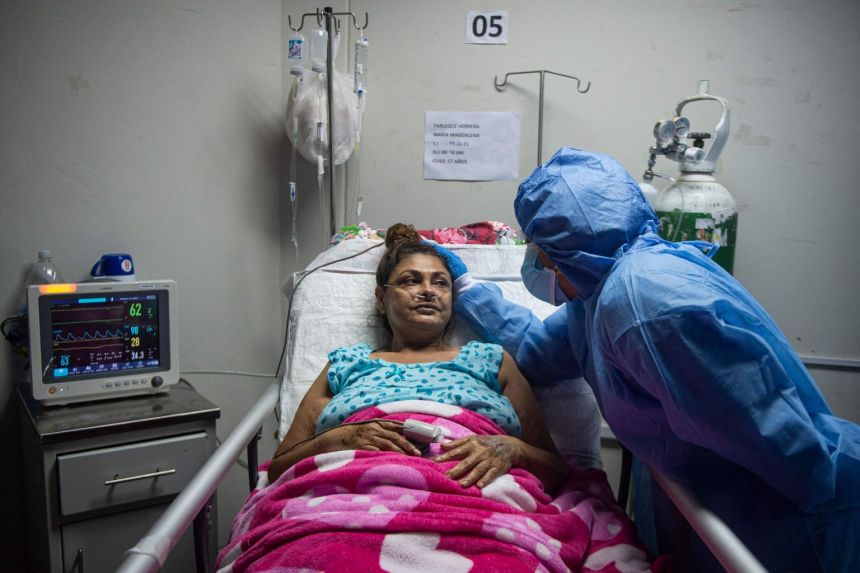 chuyên gia y tế giúp Maria Yarleque, một bệnh nhân Covid-19 tuổi, tại một bệnh viện dự phòng tại một sân vận động ở Peru. 
