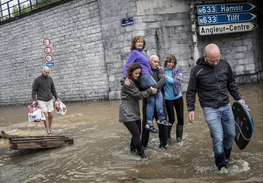 Một người phụ nữ được đưa qua con phố ngập lụt ở Angleur, tỉnh Liege, Bỉ vào tháng Bảy