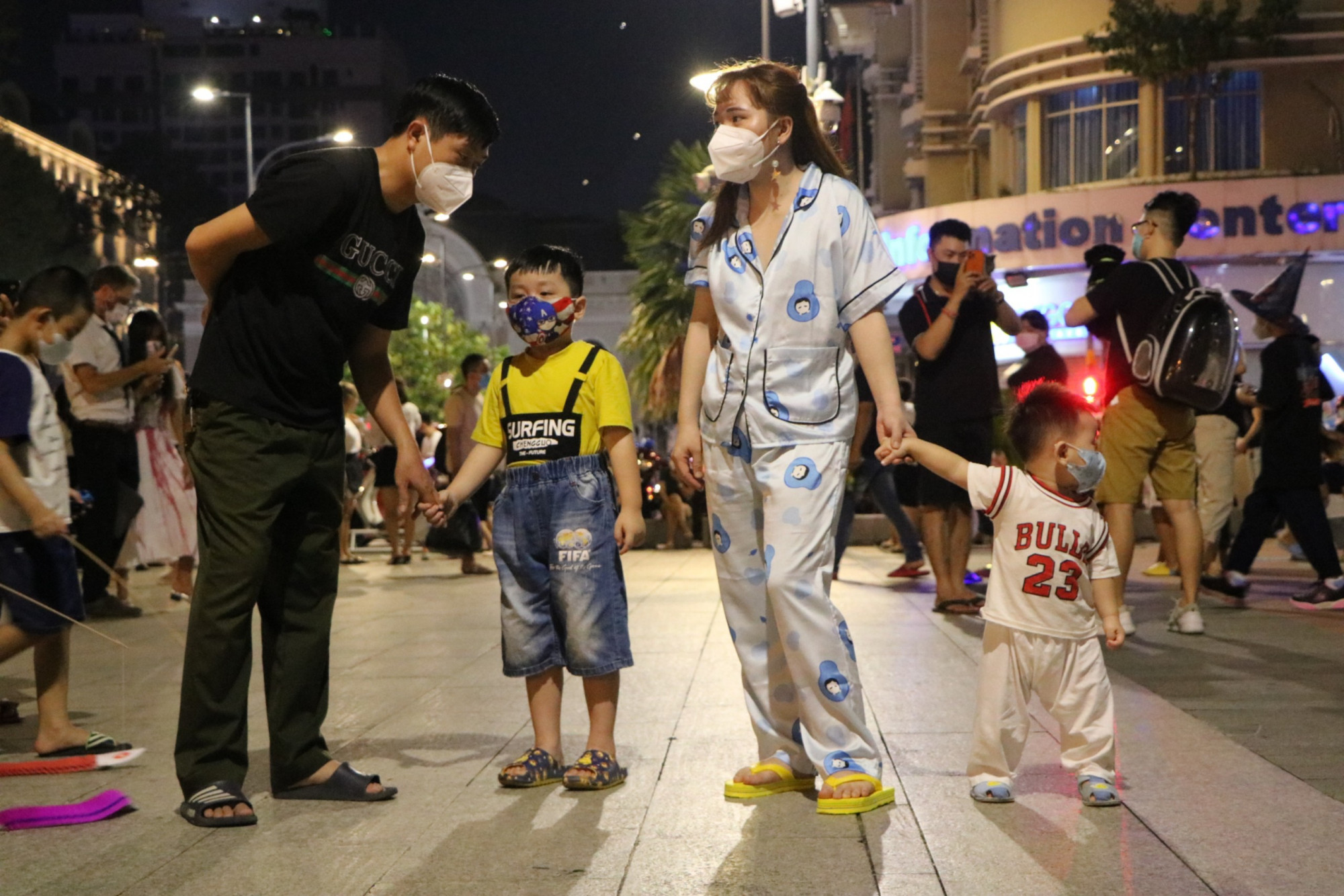 Một gia đình đưa trẻ em ra phố đi bộ Nguyễn Huệ để vui chơi Halloween