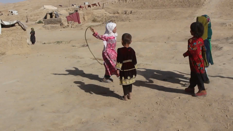 Parwana, 9 tuổi, mặc đồ màu hồng, chơi với các bạn trong trại di dời ở ngoại ô Qala-e-Naw, thuộc tỉnh Badghis của Afghanistan. Tín dụng: CNN