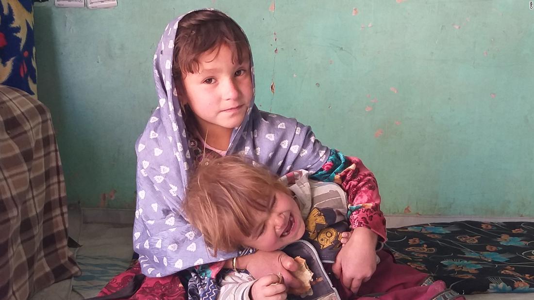 Zaiton, 4 tuổi, chơi với anh trai tại nhà của họ ở tỉnh Ghor, Afghanistan.