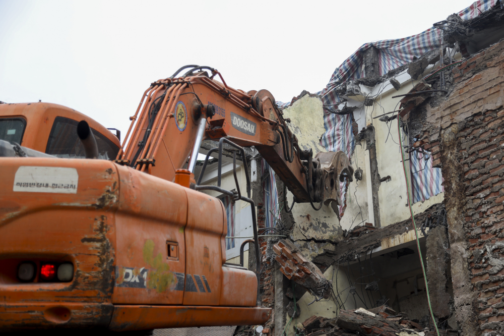 Công nhân cùng máy móc gấp rút phá dỡ ngôi nhà để trả mặt bằng cho dự án.