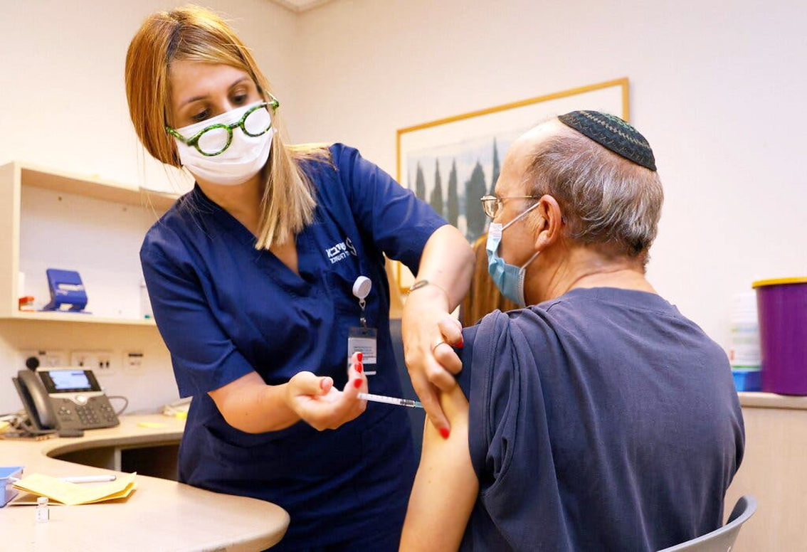 Một người đàn ông lớn tuổi ở Israel tiêm liều vắc xin COVID-19 bổ sung của Pfizer/BioNTech vào tháng 8 - Ảnh: AFP