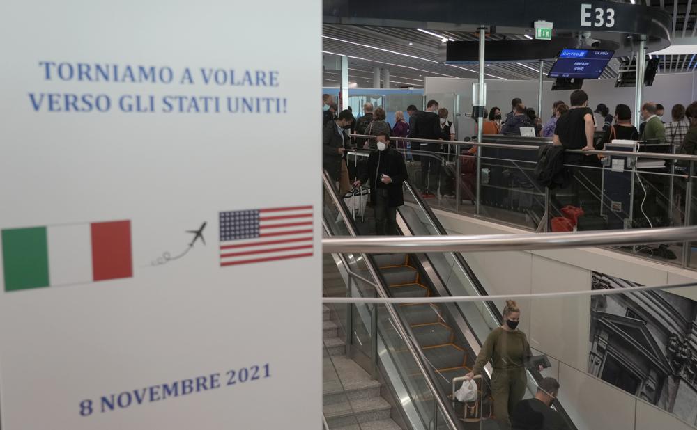 Một tấm biển ghi bằng tiếng Ý 'Chúng ta lại bay đến Mỹ' gần cổng lên máy bay của United Airlines tại sân bay Leonardo Da Vinci của Fiumicino, gần Rome hôm 8/11