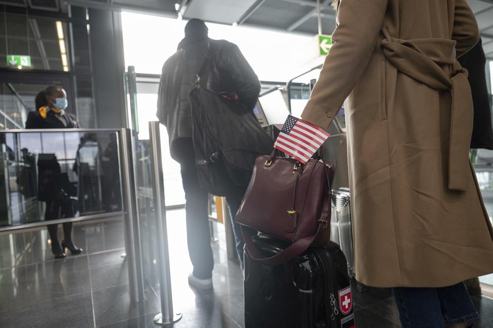 Một người phụ nữ đi qua khu vực lên máy bay tại sân bay Frankfurt, Đức với lá cờ Mỹ cho chuyến bay của hãng Lufthansa đến New York