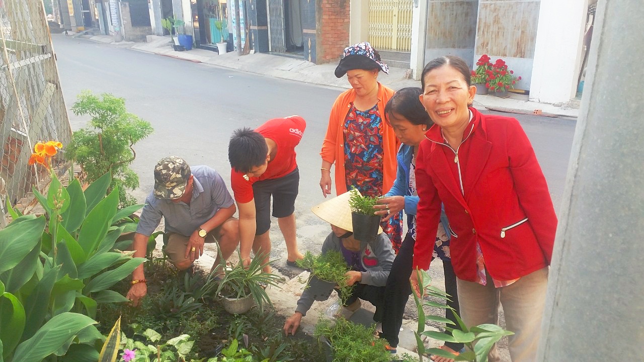 Bà Nghị (bìa phải) cùng bà con khu phố tạo dựng và chăm sóc bồn hoa trên đường TTH20 hồi đầu năm 2020.
