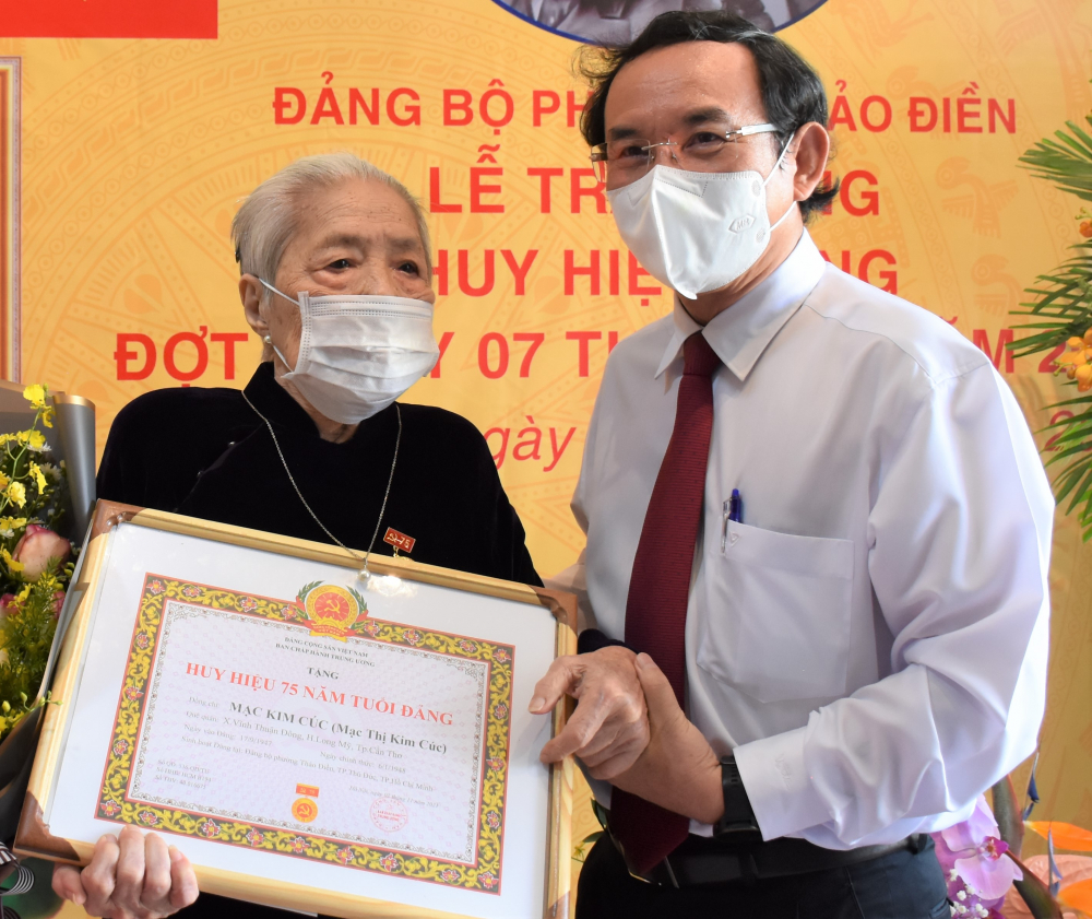 Bí thư Thành ủy TPHCM Nguyễn Văn Nên chúc mừng đảng viên Mạc Kim Cúc nhận Huy hiệu 75 năm tuổi Đảng.