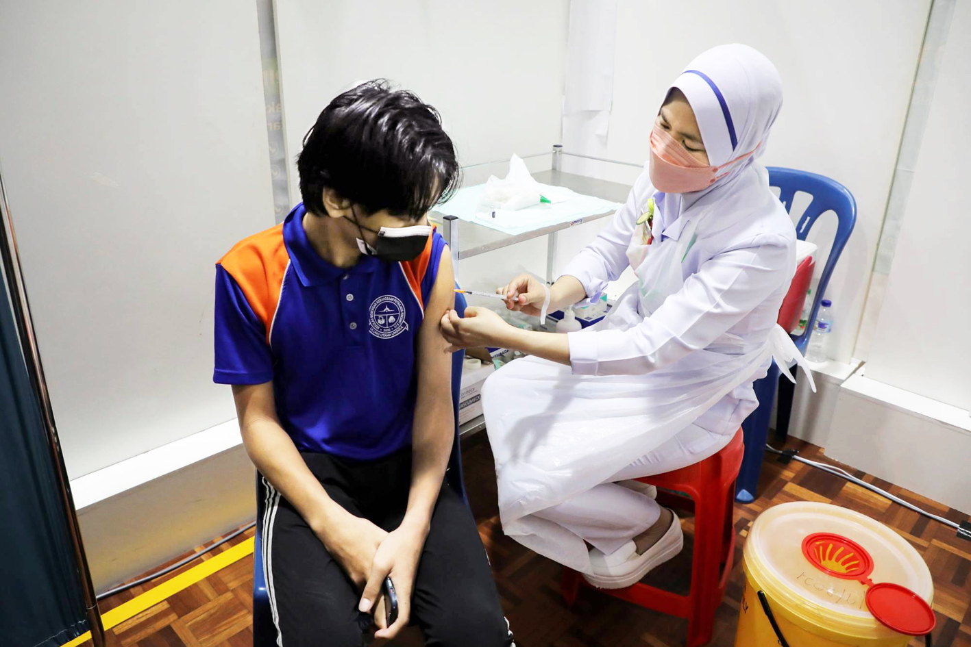 Học sinh được tiêm vắc-xin COVID-19 tại một trường học ở Putrajaya, Malaysia vào tháng Chín - ẢNH: REUTERS