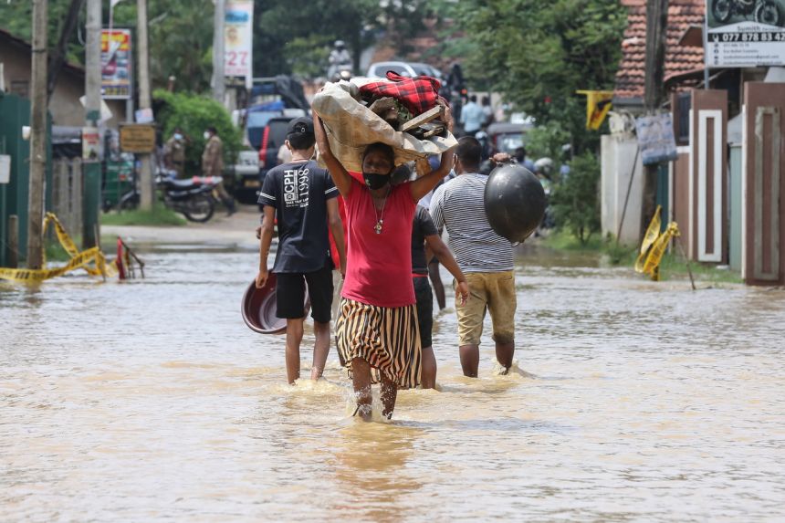 Người dân Sri Lanka lội qua một con đường ngập lụt sau trận mưa lớn.