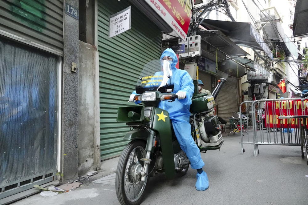 Lực lượng chức năng tiến hành phun khử khuẩn tại chợ tạm phường Phú Đô và các chục đường chính trong làng.