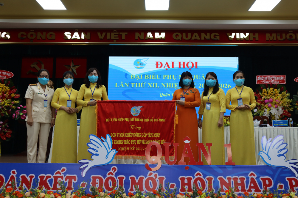 Bà Trần Thị Huyền Thanh- Phó Chủ tịch Hội LHPN TP.HCM (thứ ba từ phải sang) trao cờ khen thưởng của Hội LHPN TP cho Hội LHPN Q.1 vì có nhiều đóng góp tích cực 