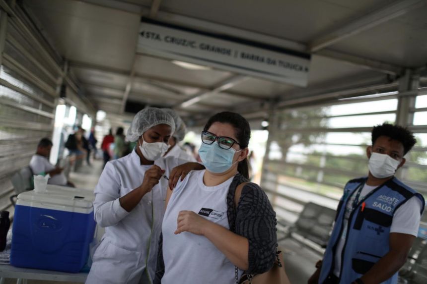 Một phụ nữ nhận một liều vắc-xin Covid-19 tại một bến xe buýt ở Rio de Janeiro 
