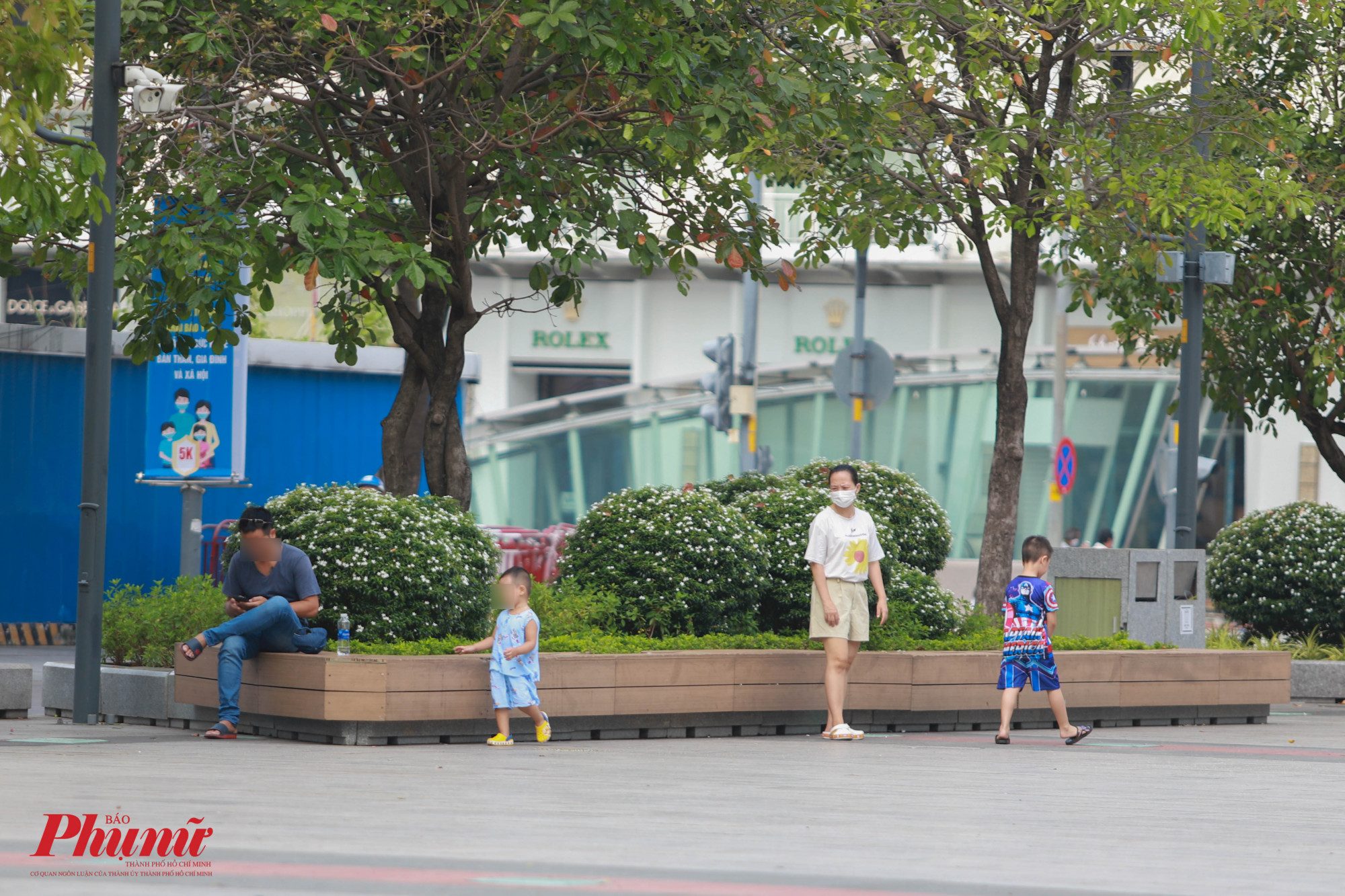 Một gia đình vui chơi trên phố đi bộ, một vài thành viên trong gia đình không đeo khẩu trang