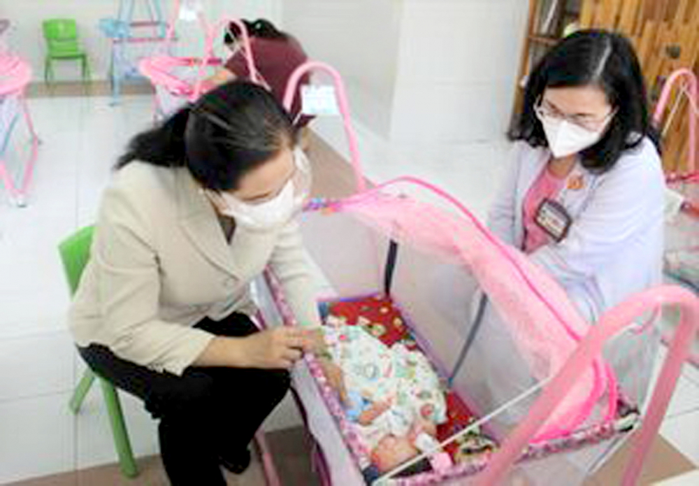 Bác sĩ Hoàng Thị Diễm Tuyết (phải) - Giám đốc Bệnh viện Hùng Vương - cùng mạnh thường quân thăm những trẻ sơ sinh cách ly mẹ bị nhiễm COVID-19 tại Trung tâm H.O.P.E. - ẢNH: TAM BÌNH