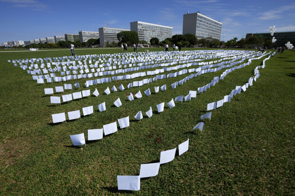 Cờ trắng đại diện cho những người đã chết vì COVID-19 ở Brazil phủ kín một cánh đồng bên ngoài tòa nhà Quốc hội ở Brasilia, Brazil