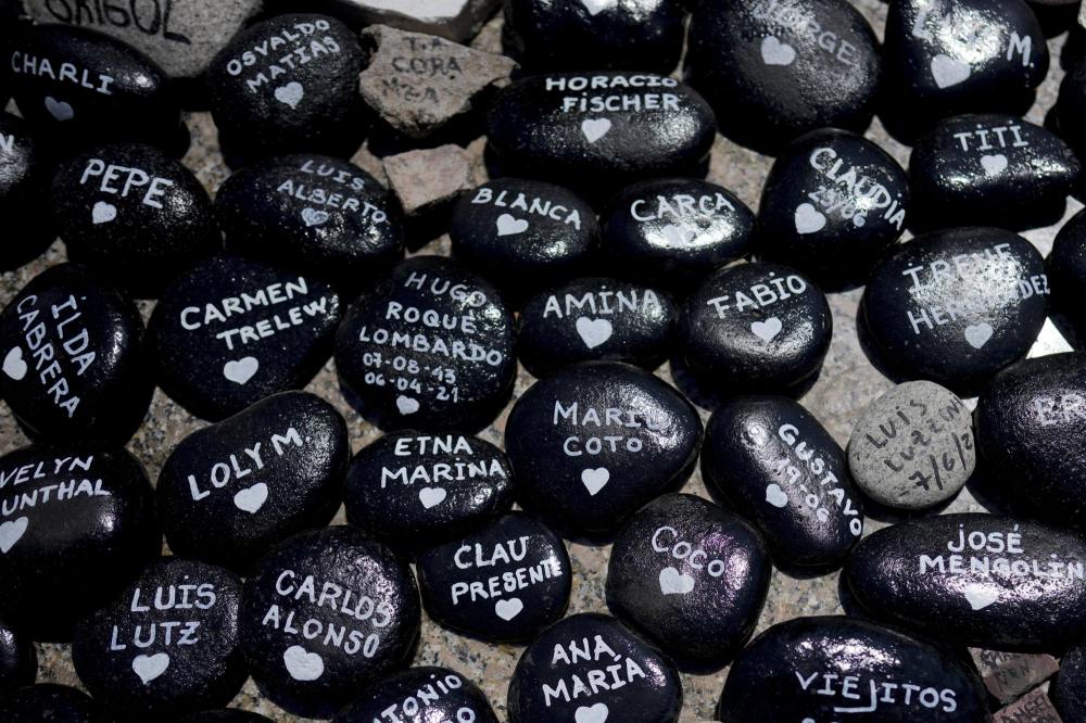Những tảng đá có tên các nạn nhân của COVID-19 phủ kín mặt đất tại một tượng đài bên ngoài tòa nhà chính phủ ở Buenos Aires, Argentina