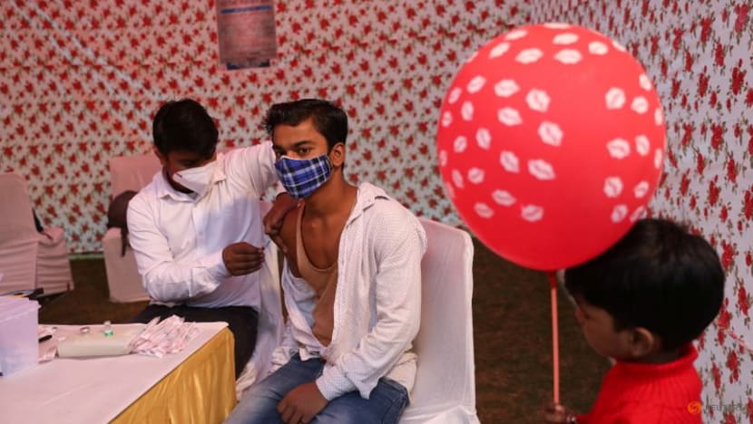 Một nhân viên y tế tiêm một liều vắc xin COVID-19 tại một trung tâm tiêm chủng được thành lập trong lễ hội tôn giáo Chhath Puja ở New Delhi vào ngày 10 tháng 11 năm 2021. (Ảnh: Reuters / Anushree Fadnavis)