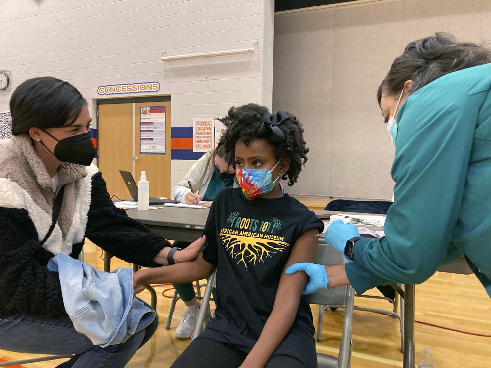 Cô bé Solome 9 tuổi đang được tiêm vắc xin Pfizer-BioNTech dành cho trẻ em - Ảnh: Laura Ungar/AP