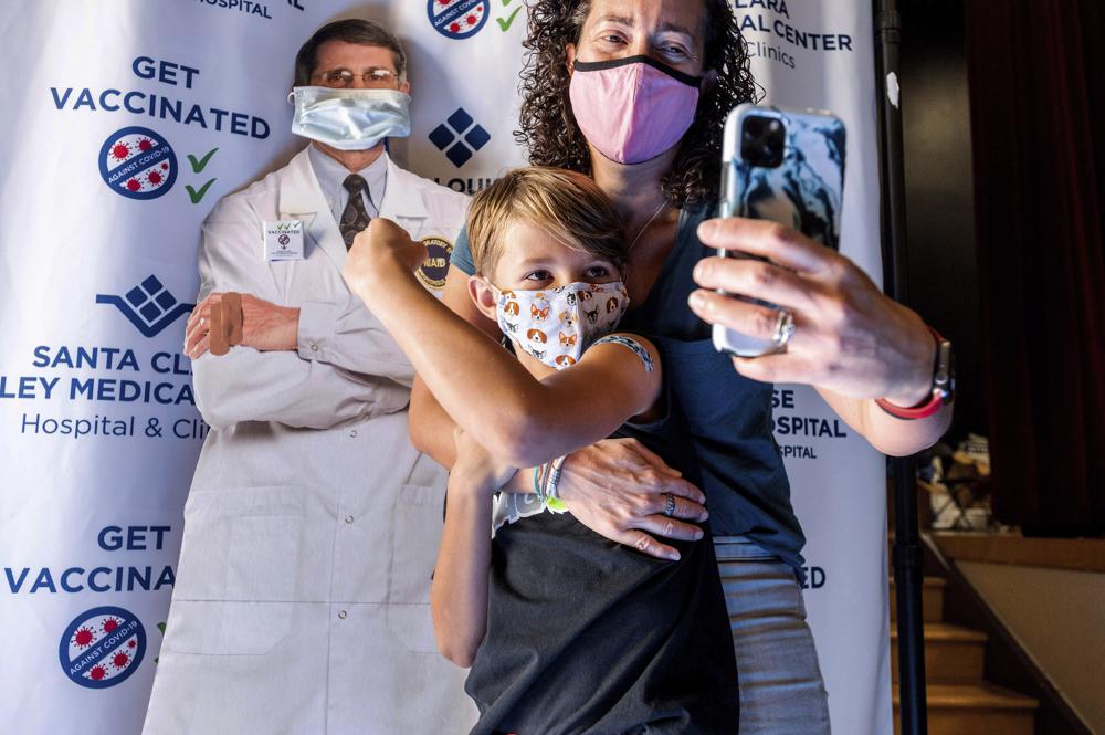 Một em bé 9 tuổi chụp ảnh cùng mẹ và bác sĩ sau khi vừa tiêm xong mũi vắc xin Pfizer-BioNTech dành cho trẻ em từ 5 đến 11 tuổi - Ảnh: Noah Berger/AP