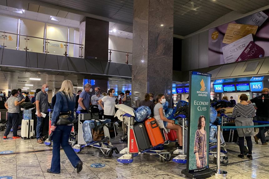 Hành khách xếp hàng để làm thủ tục đáp chuyến bay tại Sân bay Quốc tế OR Tambo ở Johannesburg, Nam Phi vào ngày 26 tháng 11 năm 2021. ẢNH: REUTERS