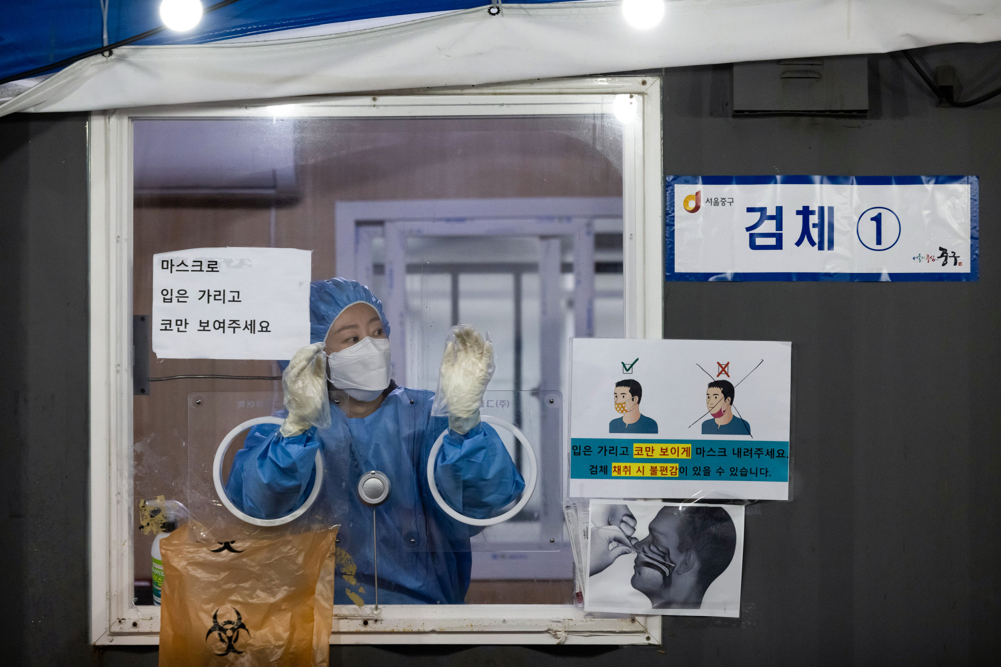 Một nhân viên y tế thực hiện xét nghiệm COVID-19 tại một địa điểm xét nghiệm tạm thời bên ngoài ga tàu ở Seoul, Hàn Quốc, vào ngày 30/11 
