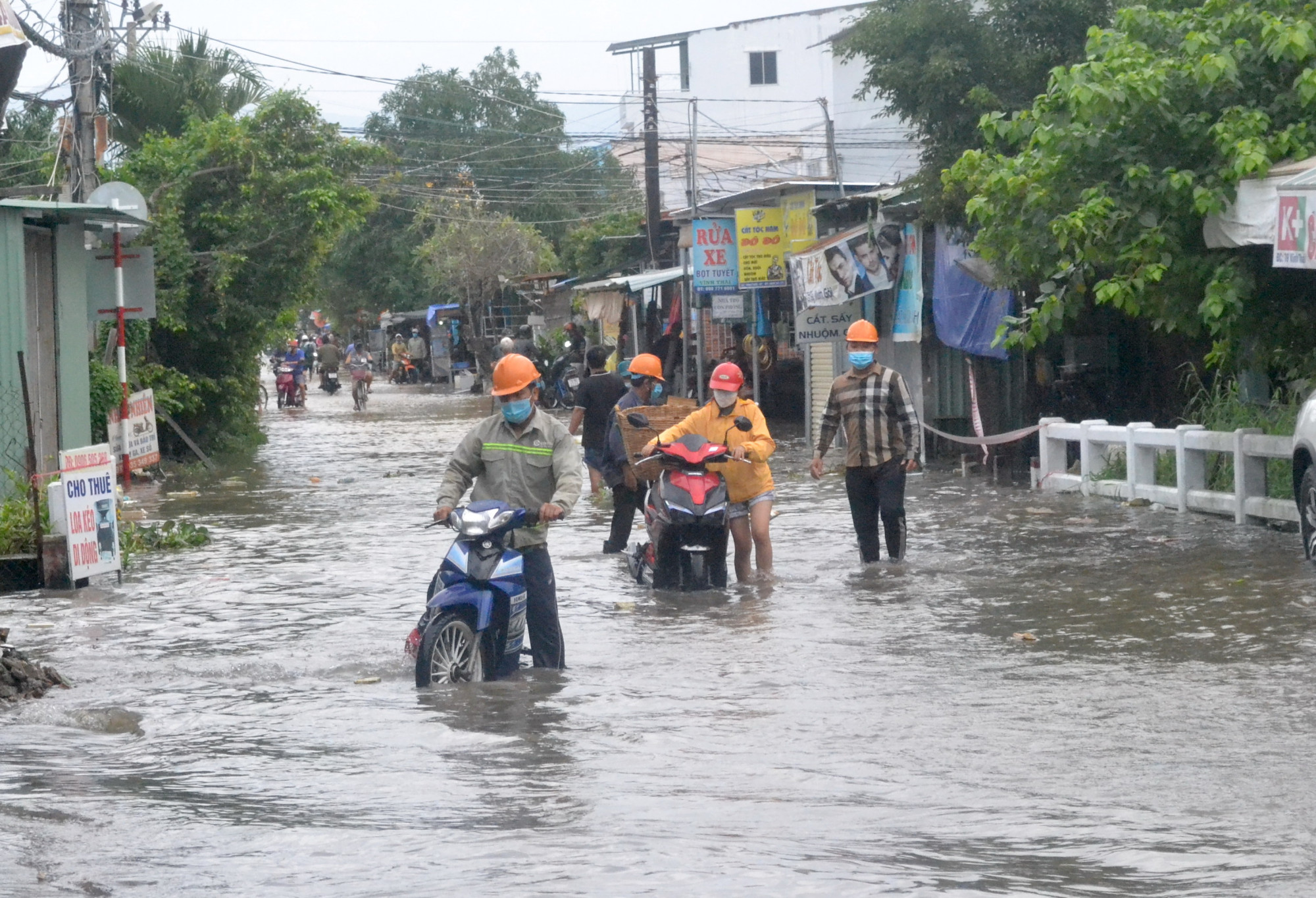 Nước ngập sâu làm xe chết máy, người dân phải dắt bộ qua đoạn đường thuộc thôn Thái Thông, xã Vĩnh Thái, TP. Nha Trang, tỉnh Khánh Hòa