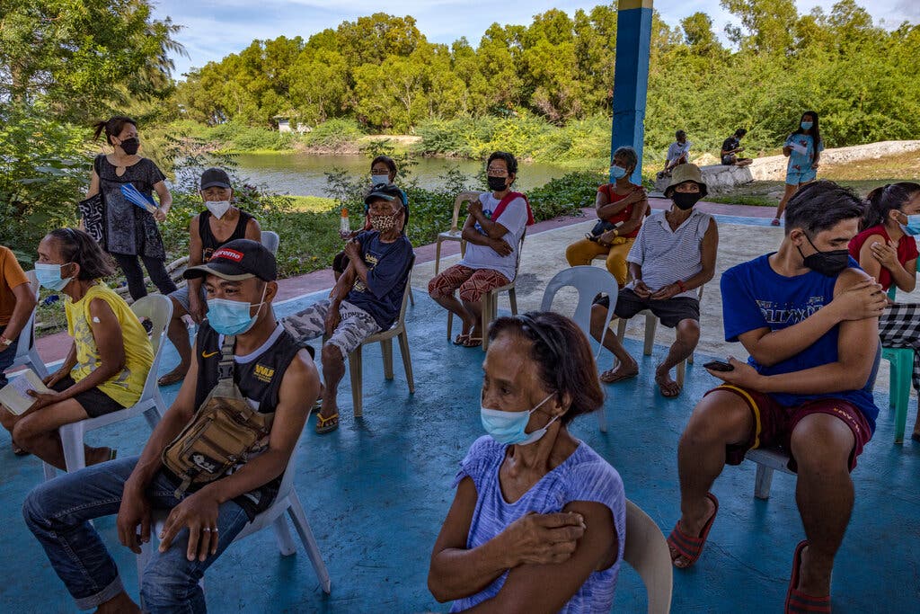 Người dân Philippines đang ngồi theo dõi sau mũi tiêm vắc xin ngừa COVID-19