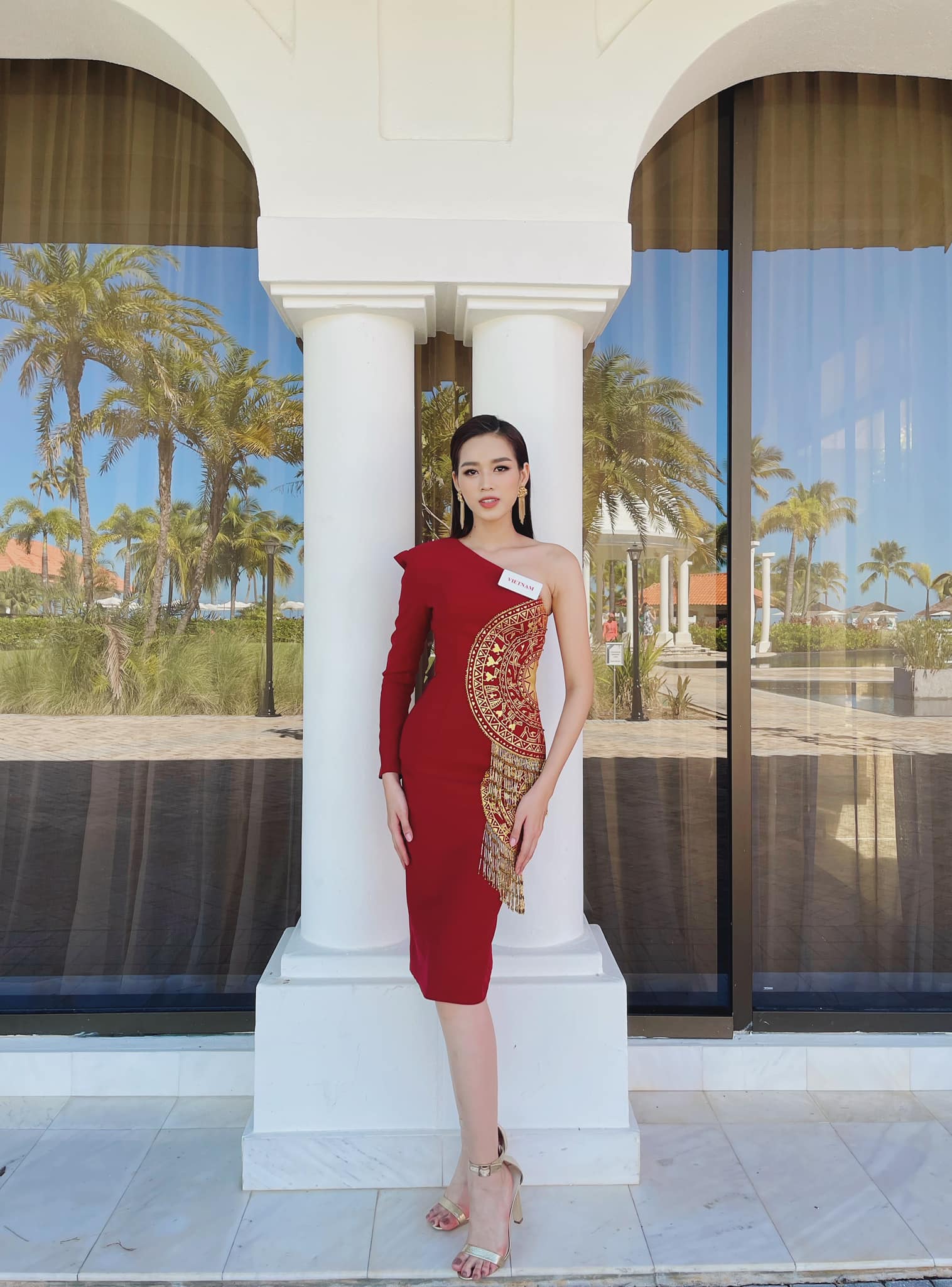 Hoa hậu Việt Nam 2020 diện váy ôm sát trong phần thi thuyết trình đối đầu. Trên nền đỏ, những chi tiết màu vàng ánh kim nổi bật, tạo điểm nhấn. Chúng mô phỏng lại những hoa văn trên trống đồng Đông Sơn.