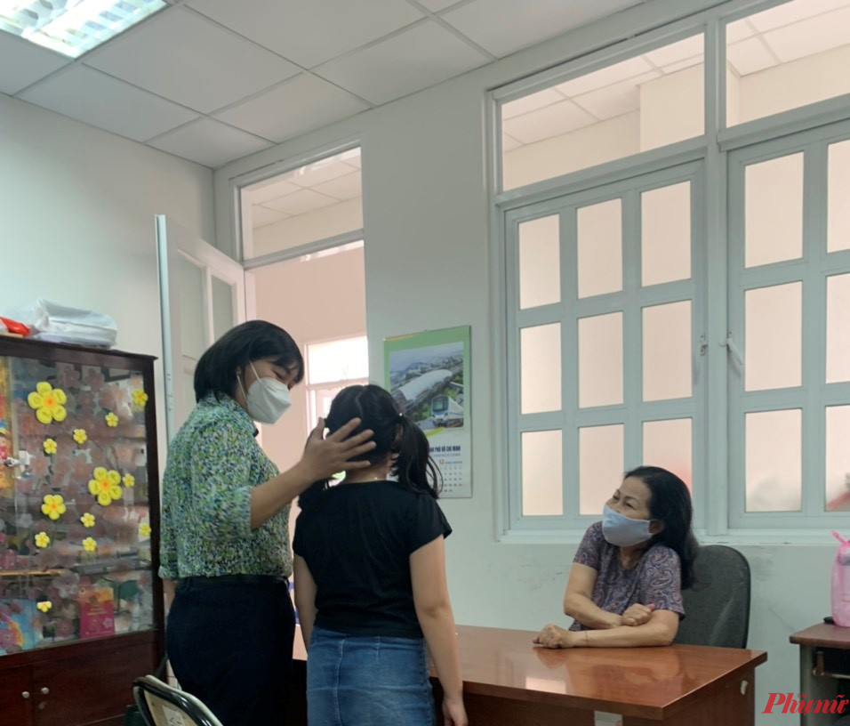 Bà Trần Thị Phương Hoa (bìa trái) - Phó Chủ tịch Hội LHPN TP.HCM và luật sư Trần Thị Ngọc Nữ đang tiếp xúc với bé N.Q. - nạn nhân trong cuộc tranh quyền nuôi con giữa cha và mẹ kéo dài