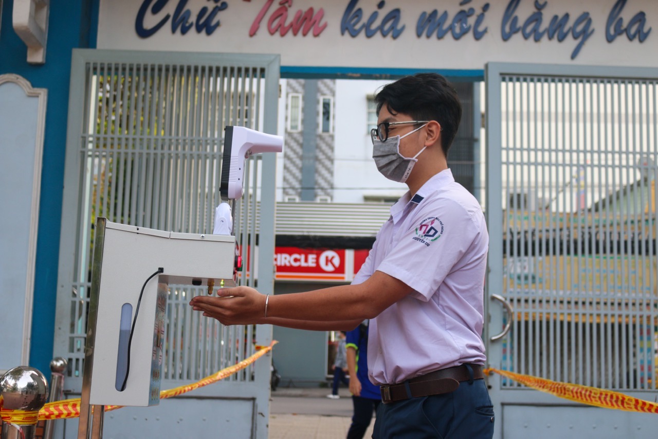 Học sinh Trường THPT Nguyễn Du được đo thân nhiệt, rửa tay sát khuẩn tai cổng trường trước khi lên lớp