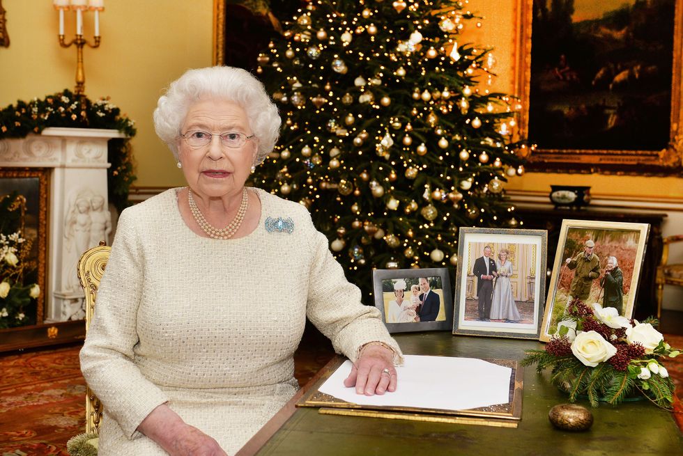 Năm 2015, nhà vua phát biểu trước quốc dân từ Phòng thế kỷ 18 của Cung điện Buckingham. Ở phía sau, bạn có thể thấy hình ảnh của Hoàng tử William, Kate Middleton và con gái của họ, Công chúa Charlotte, người được sinh ra vào đầu năm đó.