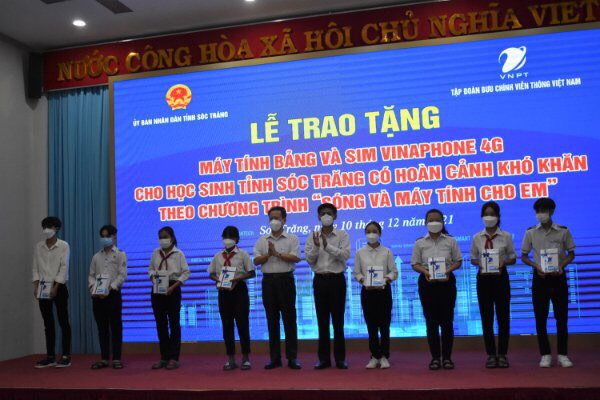 Bí thư Tỉnh ủy và Trưởng đại diện Tập đoàn VNPT tại Sóc Trăng trao tặng máy tính bảng cho các em học sinh.