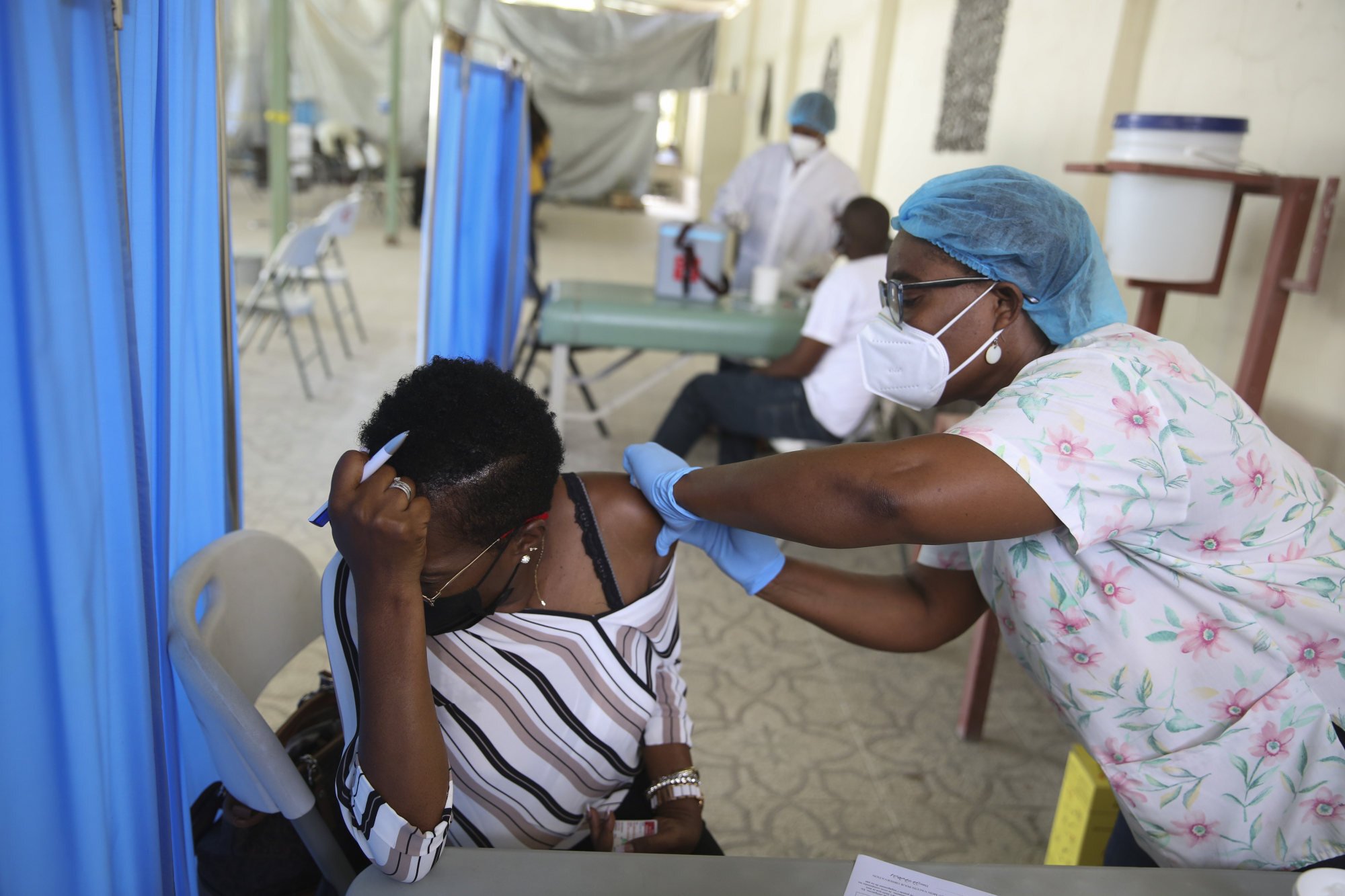 Một nhân viên y tế tiêm cho một bệnh nhân một liều vắc-xin Moderna Covid-19 được tặng thông qua sáng kiến Covax tại Bệnh viện Saint Damien ở Port-au-Prince, Haiti