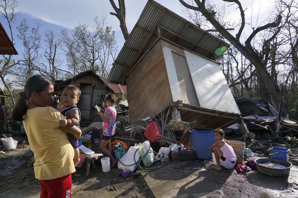 Cư dân đứng giữa những ngôi nhà bị hư hại sau cơn bão Rai ở Talisay, tỉnh Cebu
