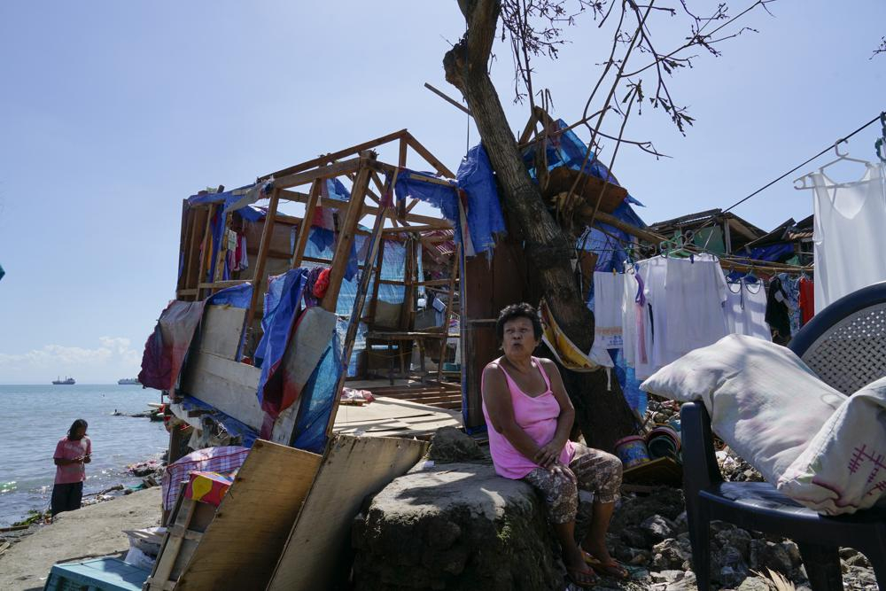 Một phụ nữ ngồi bên phần còn lại của ngôi nhà bị hư hại do bão Rai ở Talisay, tỉnh Cebu