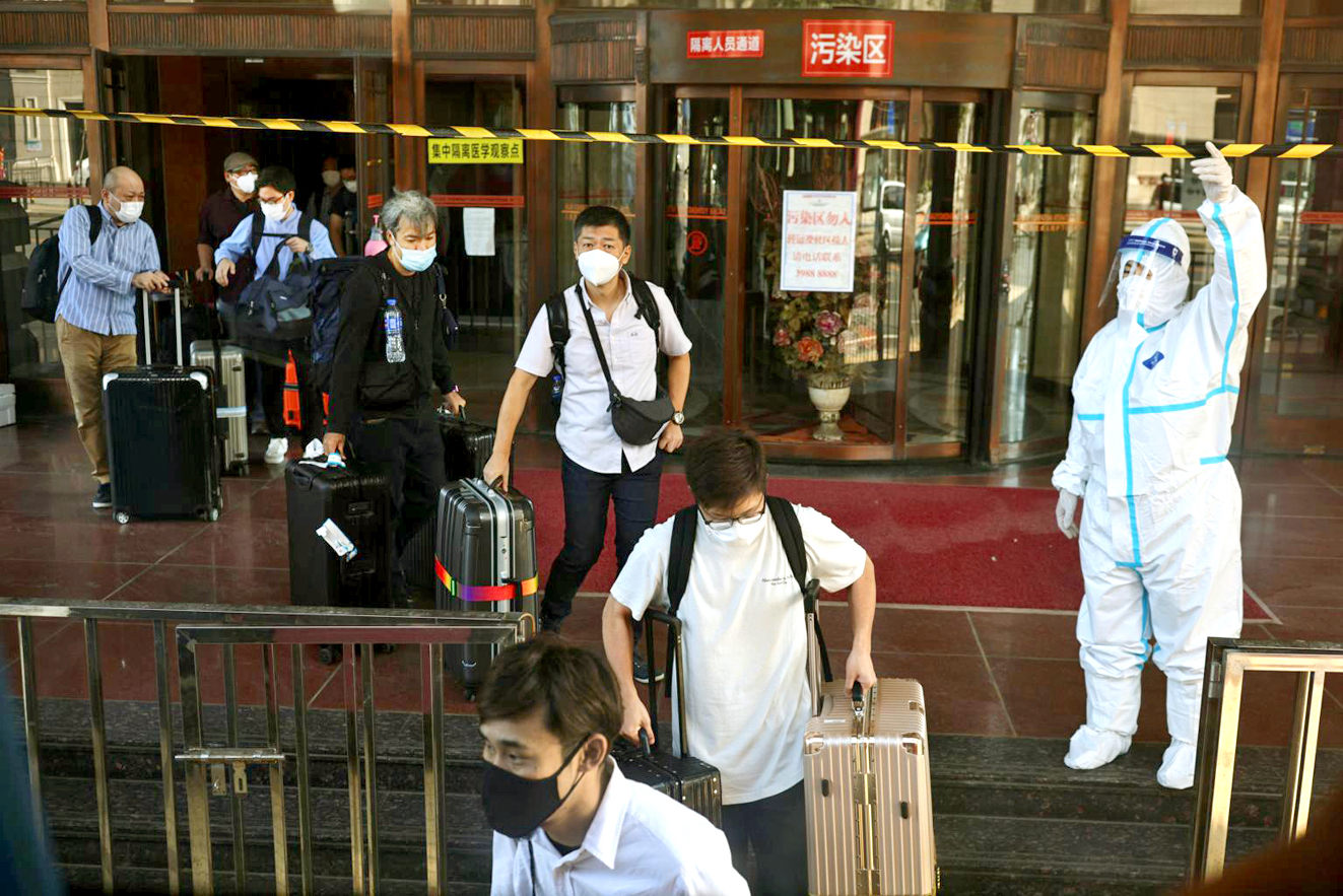 Những người từ nước ngoài đến Trung Quốc đang rời khách sạn  sau khi hoàn thành quy trình cách ly bắt buộc - ẢNH: REUTERS