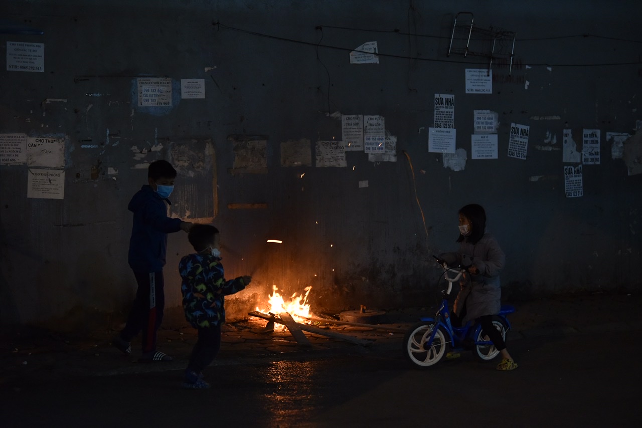Nhiều em nhỏ theo bố mẹ làm việc ngoài trời cũng phải chơi quanh các đống lửa để giữ ấm cơ thể.