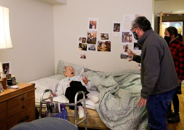 Bà Yoshia Uomoto (98 tuổi) bất ngờ khi con trai - Mark Uomoto và cháu gái Gail Yamada thực hiện chuyến thăm trực tiếp đầu tiên sau một năm ở một nhà dưỡng lão tại Seattle, bang Washington, ngày 30/3
