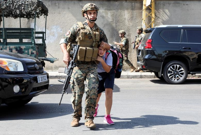 Một người lính quân đội giúp một nữ sinh chạy đến chỗ cha mẹ, sau khi vụ nổ súng xảy ra ở Beirut, Lebanon, ngày 14/10