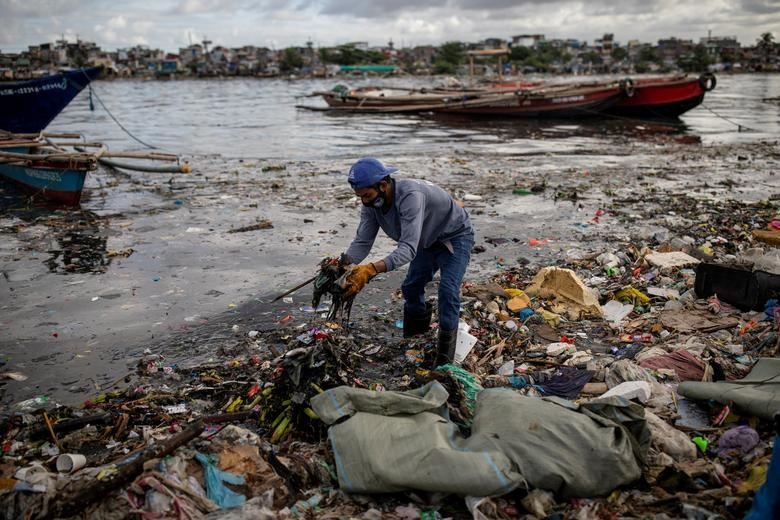 Argie Aguirre, một thành viên của nhóm River Warriors, thu gom rác thải từ sông Pasig bị ô nhiễm nặng, ở Baseco, Manila, Philippines, ngày 22/6