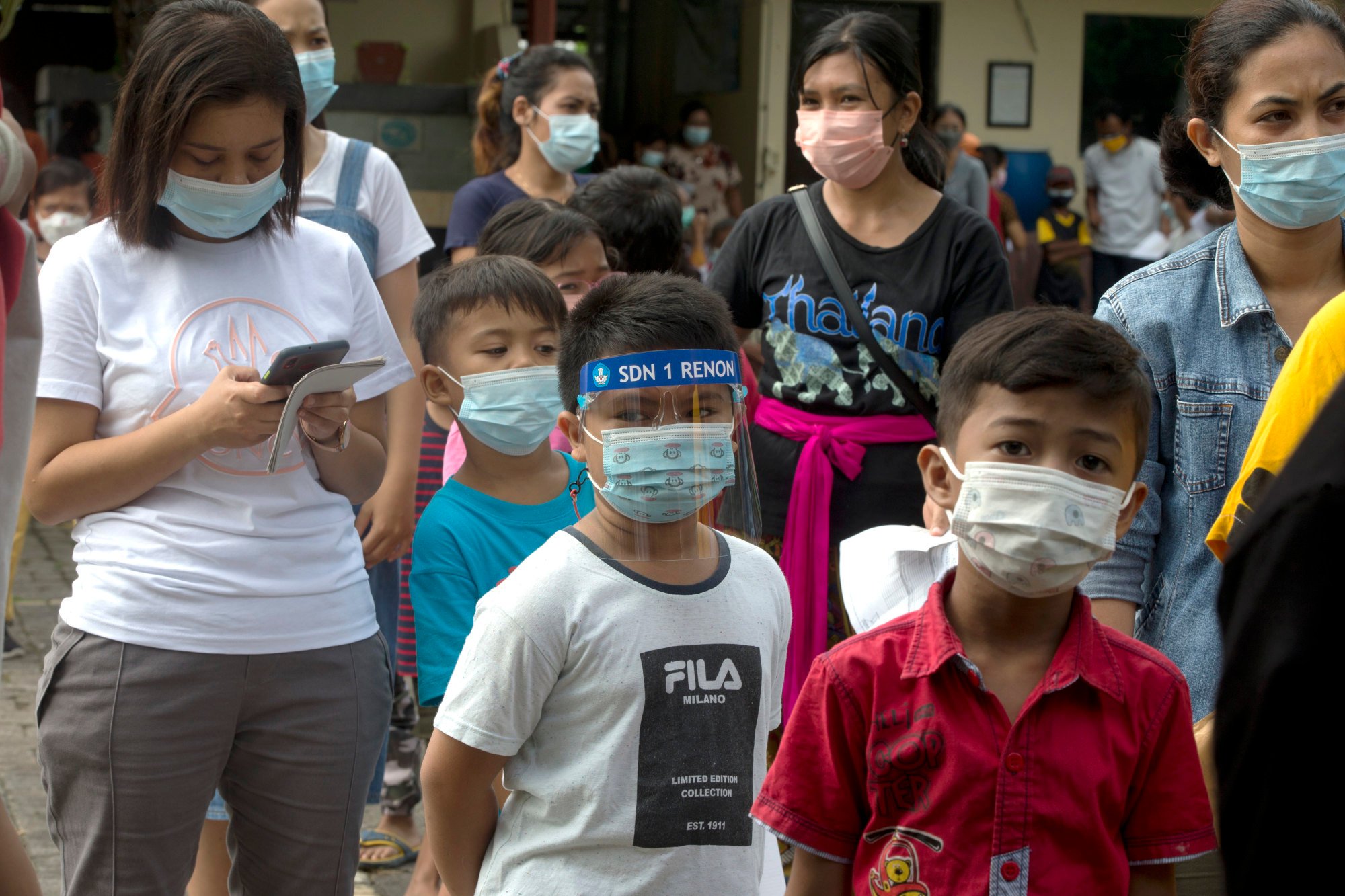 Trẻ em xếp hàng để nhận một liều vắc-xin Sinovac Covid-19 tại một trường học ở Bali, Indonesia - Ảnh: AFP