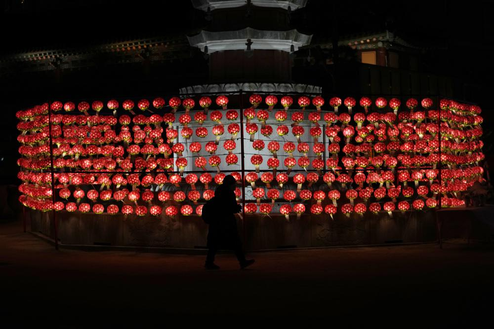 Một người phụ nữ cầu nguyện trước những chiếc đèn lồng vào đêm giao thừa tại ngôi đền Jogye ở Seoul