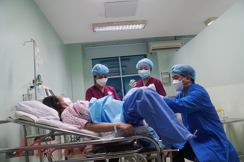 23g50, thai phụ Trần Thị Ngọc Yến (25 tuổi, ở Bình Chánh) đang cố gắng sinh con bằng sự hỗ trợ của ê-kíp bác sĩ Bệnh viện Hùng Vương TPHCM